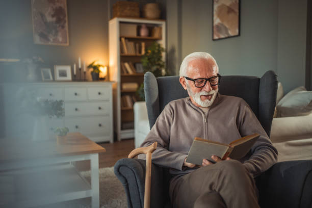 istock An elderly man reads a book at home while relaxing in his comfortable armchair 2187119212