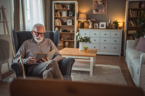 istock An elderly man reads a book at home while relaxing in his comfortable armchair 2187119225