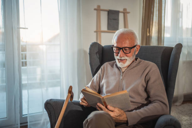 istock An elderly man reads a book at home while relaxing in his comfortable armchair 2187119226
