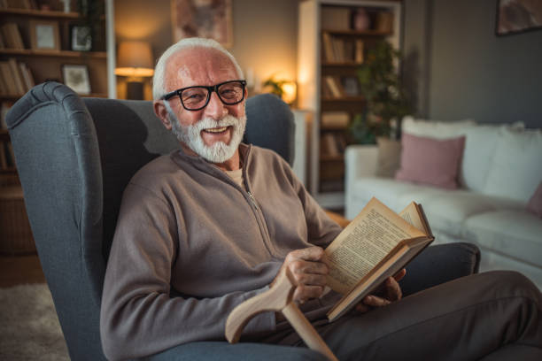 istock An elderly man reads a book at home while relaxing in his comfortable armchair 2187119230
