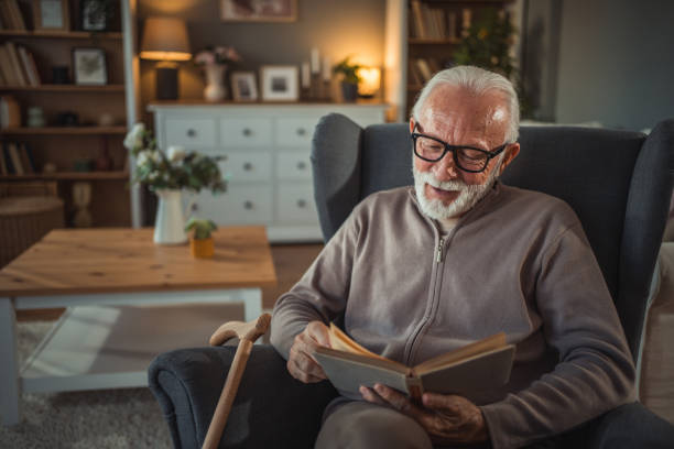 istock An elderly man reads a book at home while relaxing in his comfortable armchair 2187119231