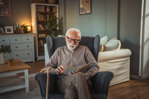 istock An elderly man reads a book at home while relaxing in his comfortable armchair 2187119242