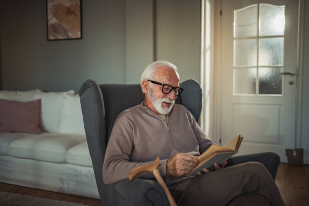 istock An elderly man reads a book at home while relaxing in his comfortable armchair 2187119252