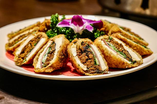 istock Fried stuffed tofu slices with garnish and flower on a plate 2187119286