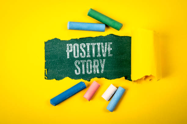 istock Positive Story. Text under torn yellow paper on a green chalkboard 2187119549