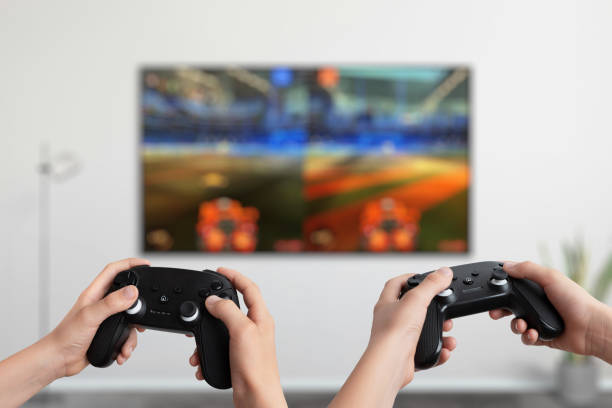 istock Two players holding gamepads in front of a TV playing a split-screen action game, showcasing interactive multiplayer gaming and dynamic entertainment 2187127795