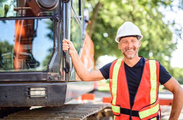 istock caucasian engineer with white helmet at work and having a mechanical shovel on the back 2187131299
