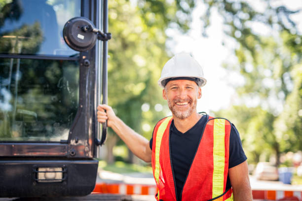 istock caucasian engineer with white helmet at work and having a mechanical shovel on the back 2187131307