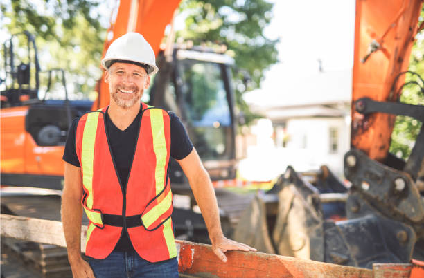 istock caucasian engineer with white helmet at work and having a mechanical shovel on the back 2187131324