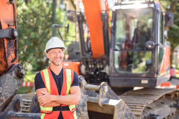istock caucasian engineer with white helmet at work and having a mechanical shovel on the back 2187131326