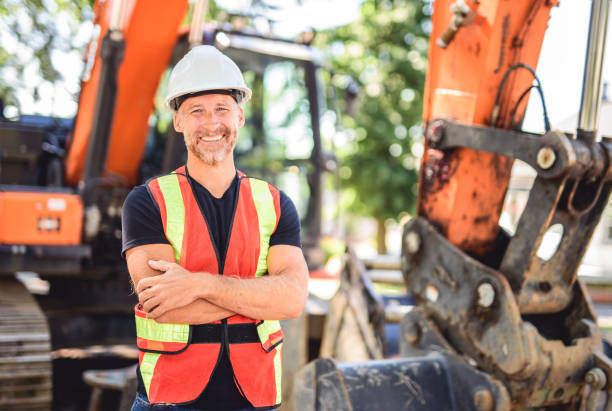 istock caucasian engineer with white helmet at work and having a mechanical shovel on the back 2187131332