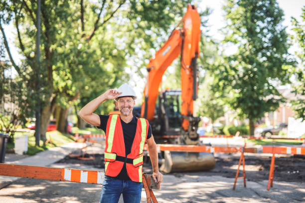 istock caucasian engineer with white helmet at work and having a mechanical shovel on the back 2187131337