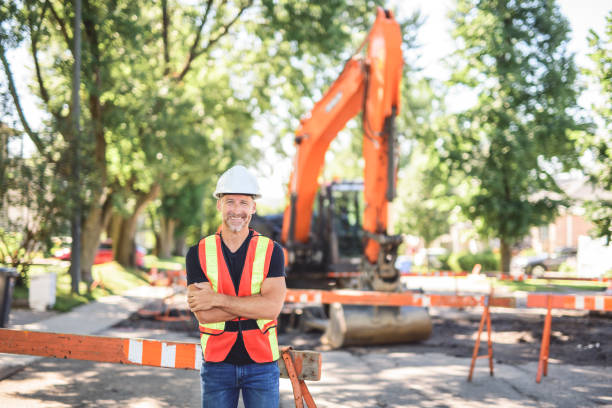 istock caucasian engineer with white helmet at work and having a mechanical shovel on the back 2187131340