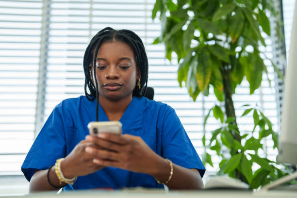 istock Young healthcare worker using mobile phone at the doctor's office. 2187131344