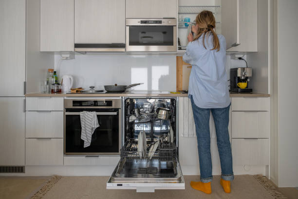 istock Woman organizing kitchen while dishwasher is open in modern home kitchen. 2187131571