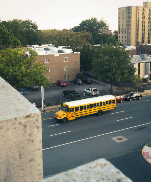Yellow school bus driving through the city dropping off children