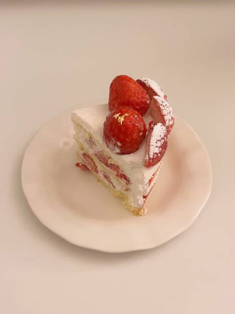top view of sweet cake with strawberries and cherries on pink plate and pink stone board