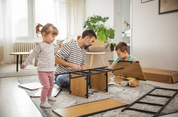 istock Happy father and kids assembling furniture 2187137981