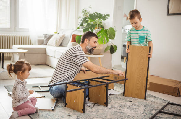 istock Happy father and kids assembling furniture 2187138312