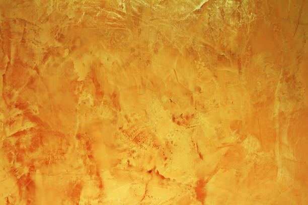 Empty golden textured background with copy space. Artistic tadelakt and luxury background. Decorative yellow painted wall
