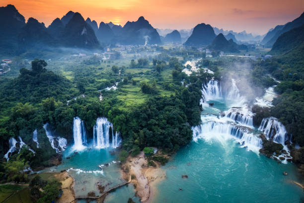 istock Sunset over mountain range with Ban Gioc waterfall flowing in tropical rainforest at Vietnam 2187142741