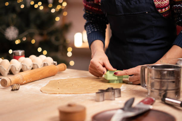 istock Woman cutting cookie shapes from raw dough on table 2187142901
