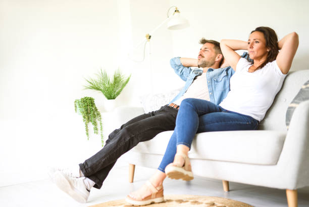 istock Beautiful couple is having a quarrel while sitting on sofa at home 2187143134