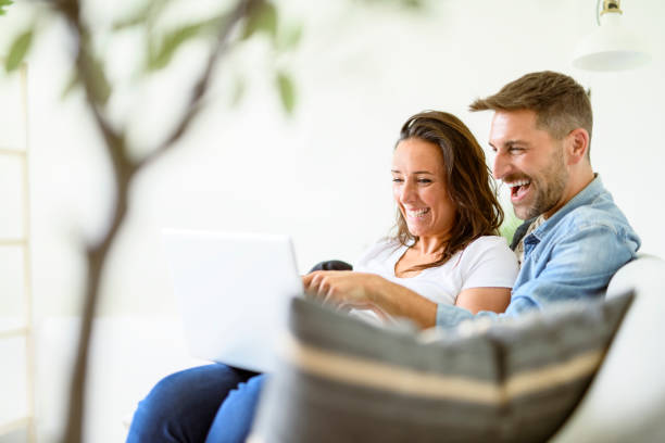 istock bearded husband cuddling affectionate wife on computer at home. Using laptop in living room. 2187143176