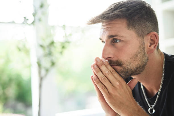 istock Sad bearded man in casual sitting on couch at home 2187145729