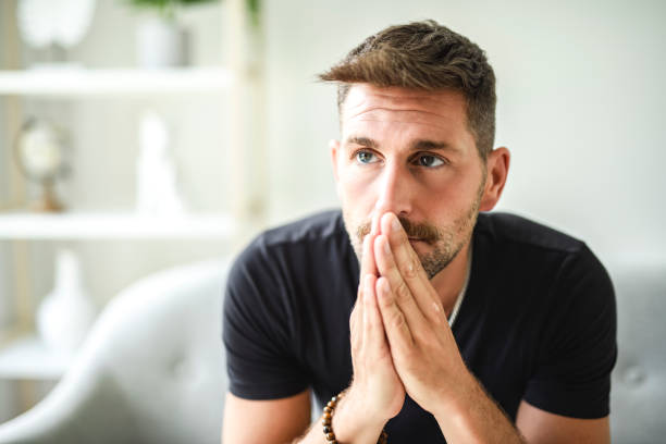 istock Sad bearded man in casual sitting on couch at home 2187145731