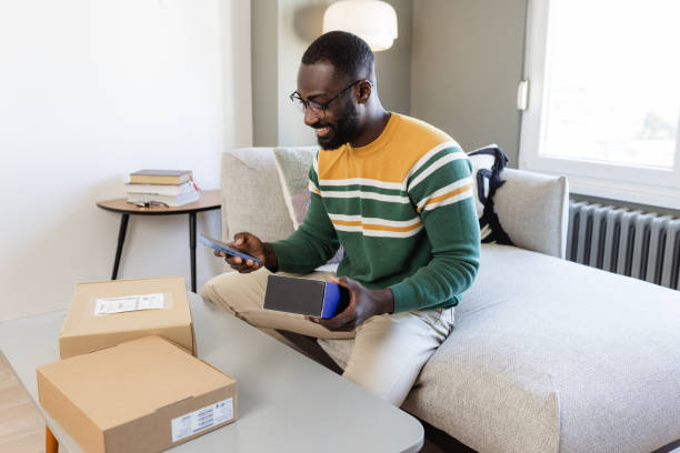 istock Man receiving online delivery at home, smiling and using smart phone 2187145789