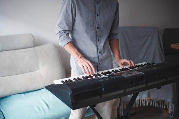 istock Musician's hands actively playing a digital keyboard, blending focus and creativity in a modern home setting with soft lighting and minimalist decor 2187148105