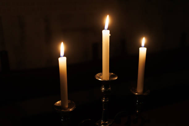 istock Three glowing candles burning in the dark, creating a serene and tranquil atmosphere 2187156284
