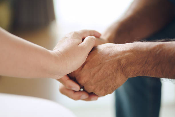 Female friend or family sitting and hold hands during cheer up to mental depress man Female friend or family sitting and hold hands during cheer up to mental depress man, Psychologist provides mental aid to patient. PTSD Mental health concept. couple hope sky blue stock pictures, royalty-free photos & images
