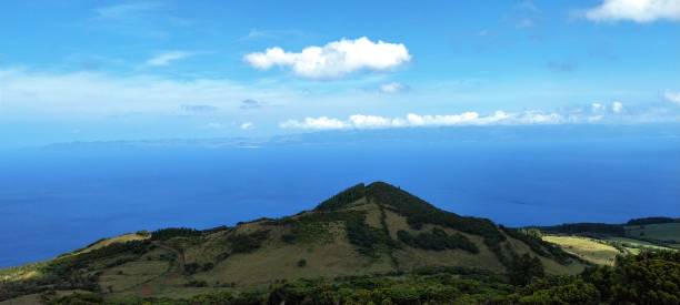 With a green hill and island of Sao Jorge in the background
