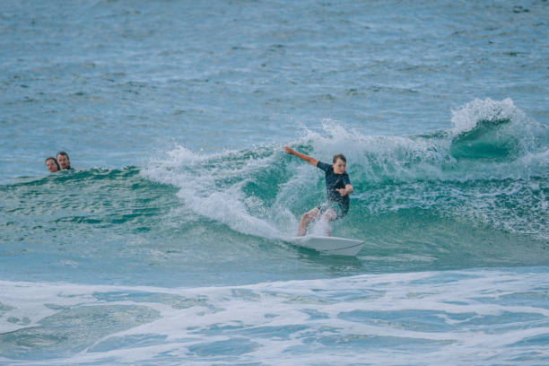istock young Australian boy surfing in gold coast while father and sister watching 2187162093