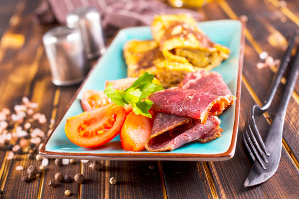 omelet with smoked meat, tomato and spice on plate