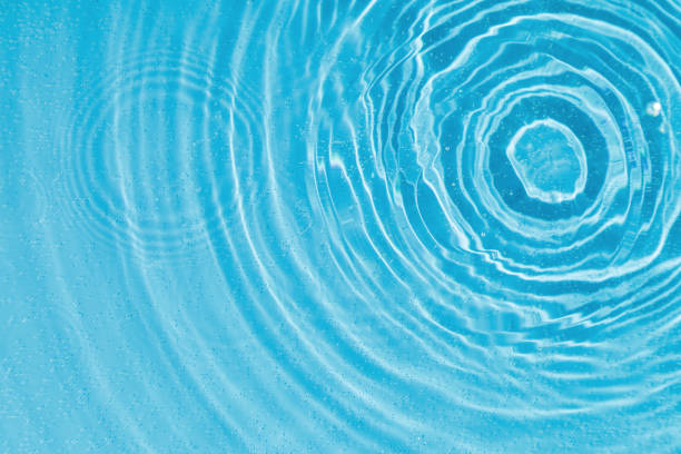 istock drops on water with circles on a blue background 2187165680