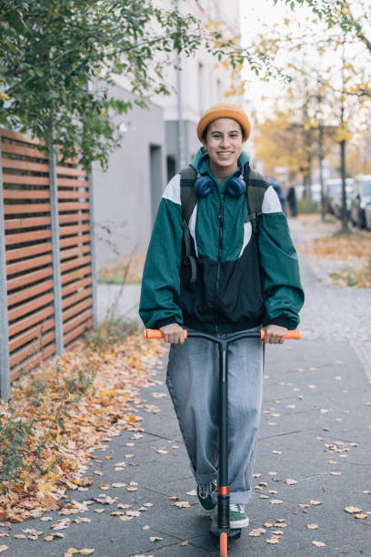istock Young student going to school on scooter in autumn 2187165722