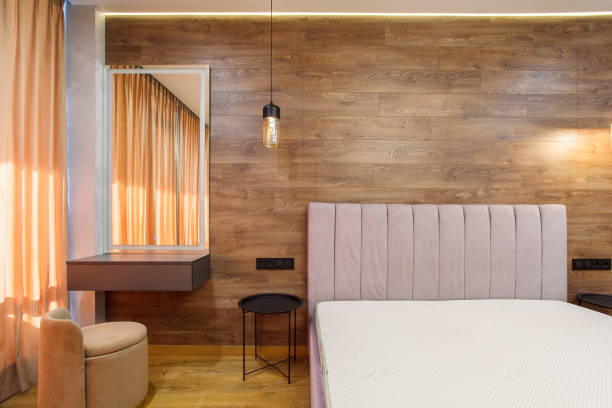 large modern bedroom. bed with headboard wooden laminate on wall