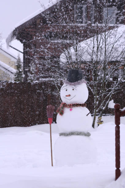 istock Kind snowman with a broom and snowfall 2187167841
