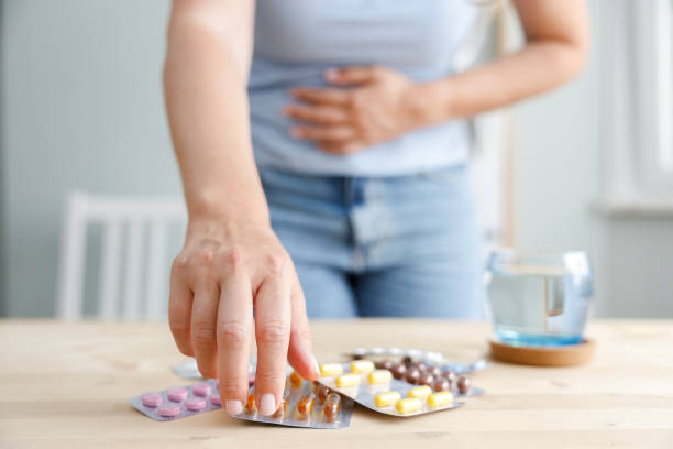 istock Woman suffering from stomach ache reaches for medication 2187168113