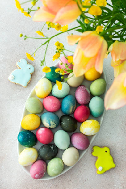 istock Multi-colored Easter eggs in an oval dish with decorative bunnies, top view 2187168585