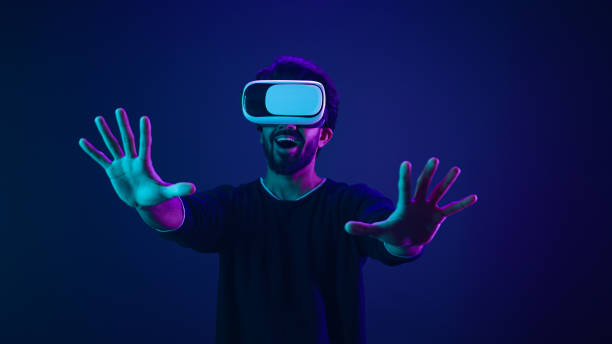 istock Metaverse virtual reality cyberspace world man play game playing guy meta universe experience digital technology with VR goggles helmet cyber gamer neon ultraviolet futuristic space cyberpunk gaming 2187171950