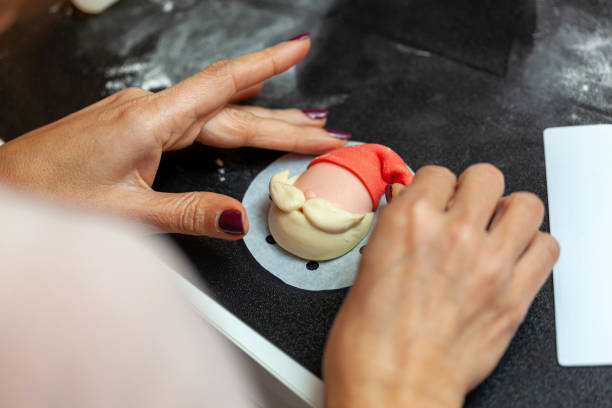 istock Baker creating christmas themed bread shaped like santa claus face 2187173616