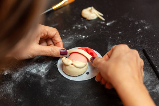 Baker making christmas themed bread shaped like santa claus