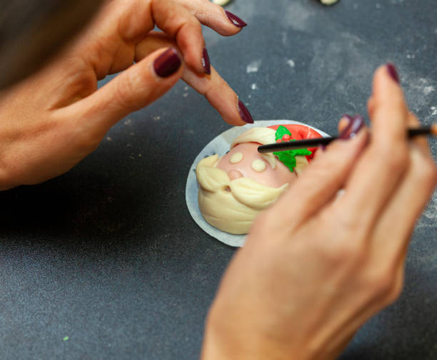 istock Baker adding finishing touches to santa claus steamed bun 2187173639