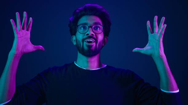 istock Close up man portrait Muslim coder in neon studio ultraviolet background Arabian man Indian guy make mind explosion gesture cyberspace hacking programming difficulties problem showing head boom idea 2187173771
