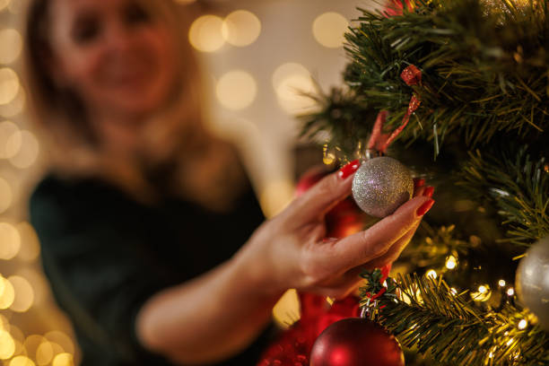 istock Festive indoor scene with a woman decorating a tree 2187173904