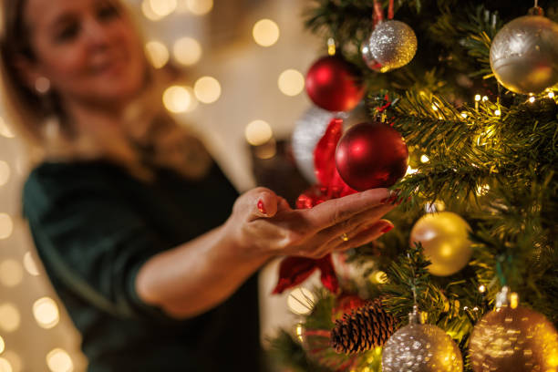 istock Indoor holiday decorating with a woman and a Christmas tree 2187173912